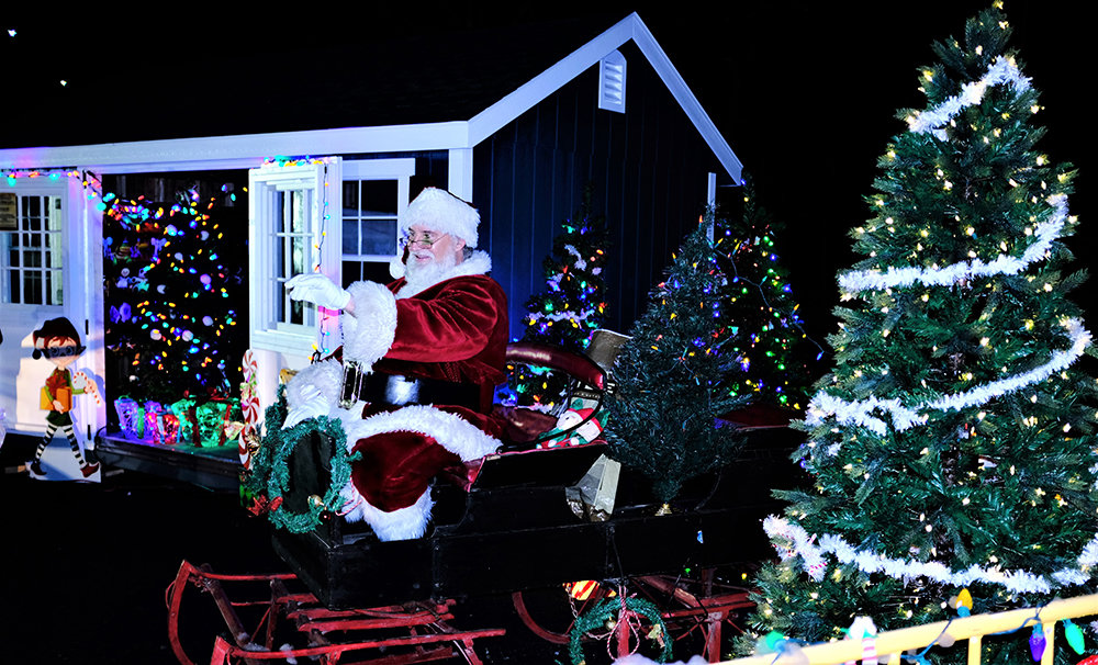 Santa held court atop his sleigh by his Christmas trees and his workshop.